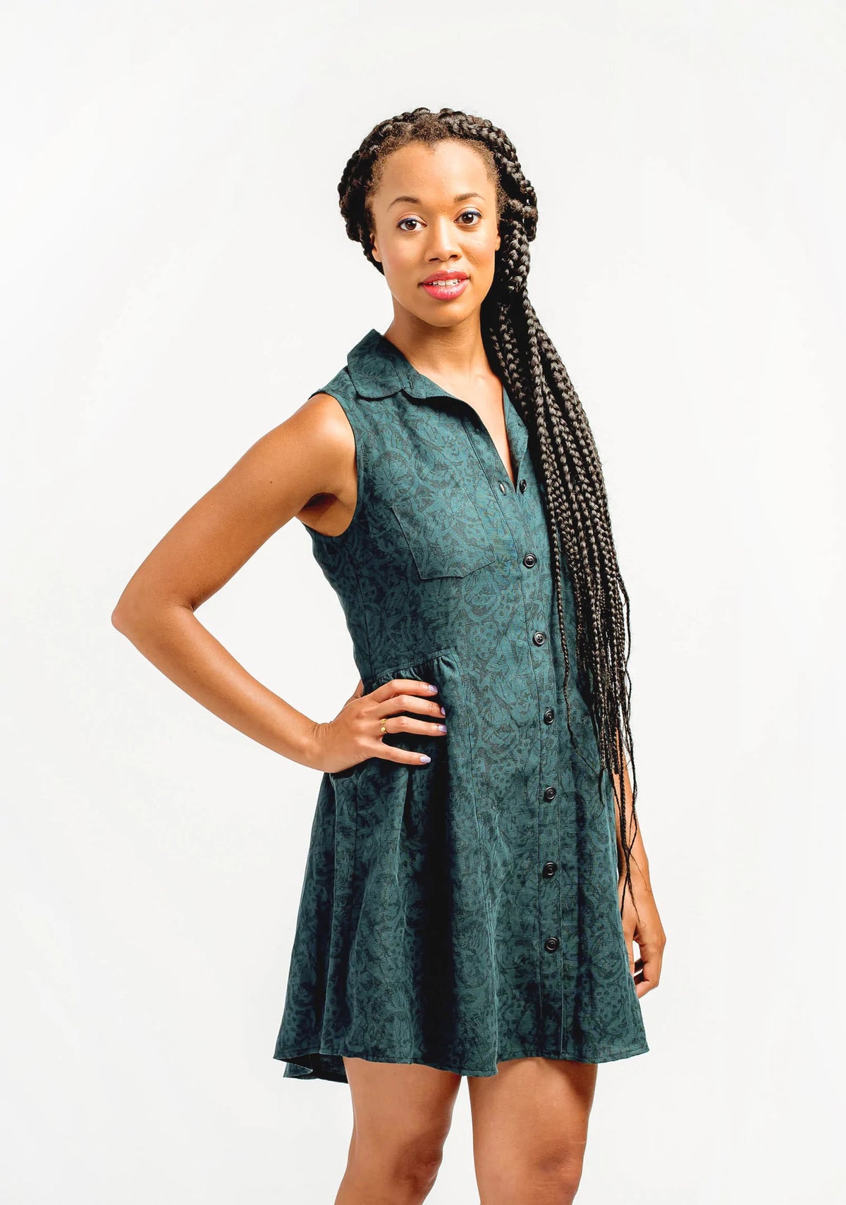 Model Lauren is wearing a size 8, view B Alder Shirtdress in a green patterned fabric. She is modeling the front side of the shirtdress.