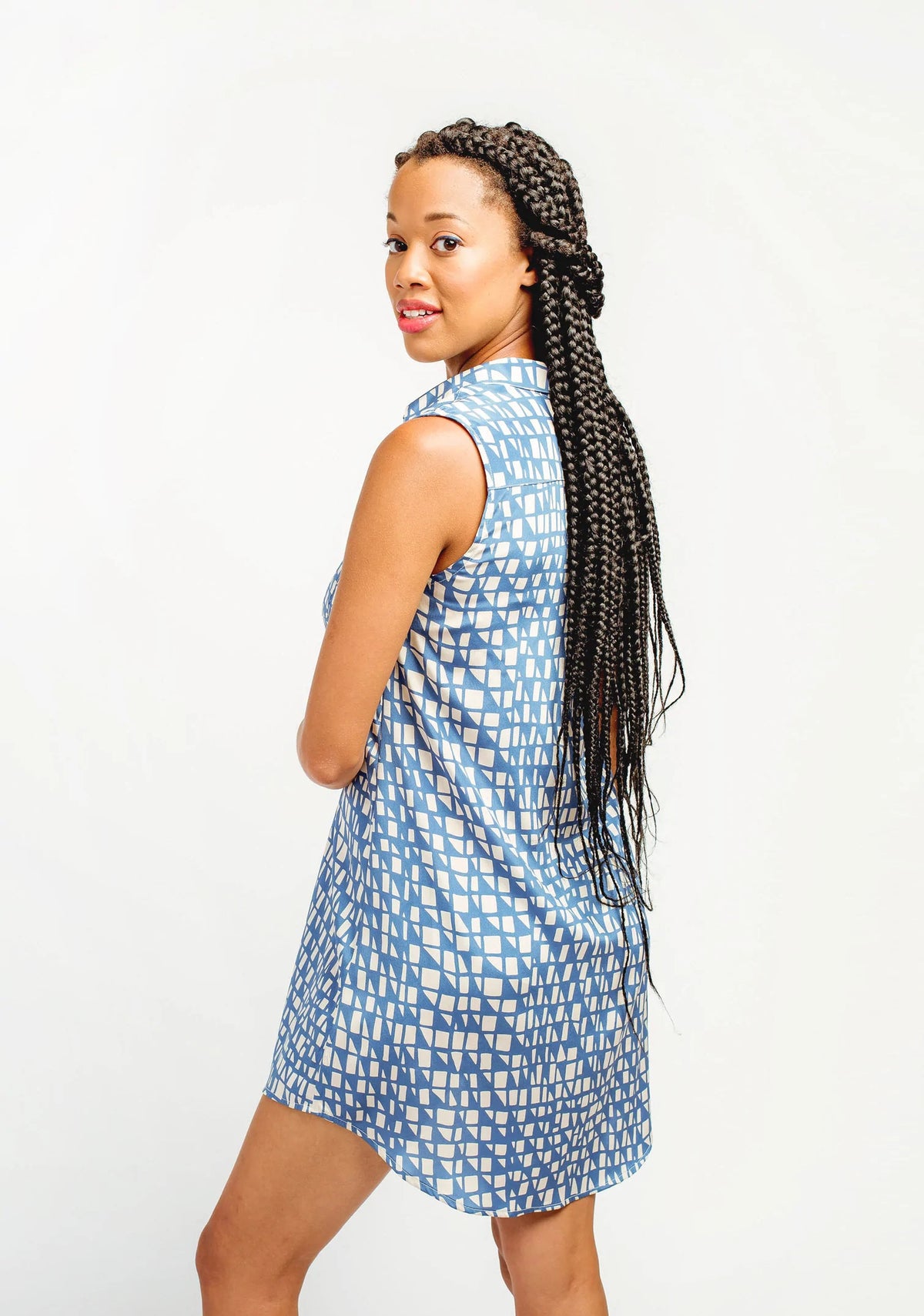Model Lauren is wearing a size 8, view A Alder Shirtdress in a blue patterned fabric. She is modeling the back side of the shirtdress.