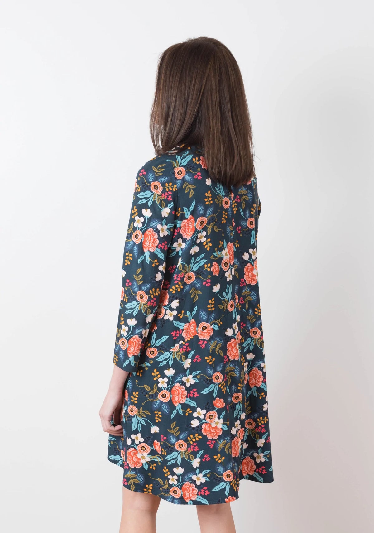 Model Kari is wearing a size 6 Farrow in a floral fabric, back view. This pattern has sleeves.